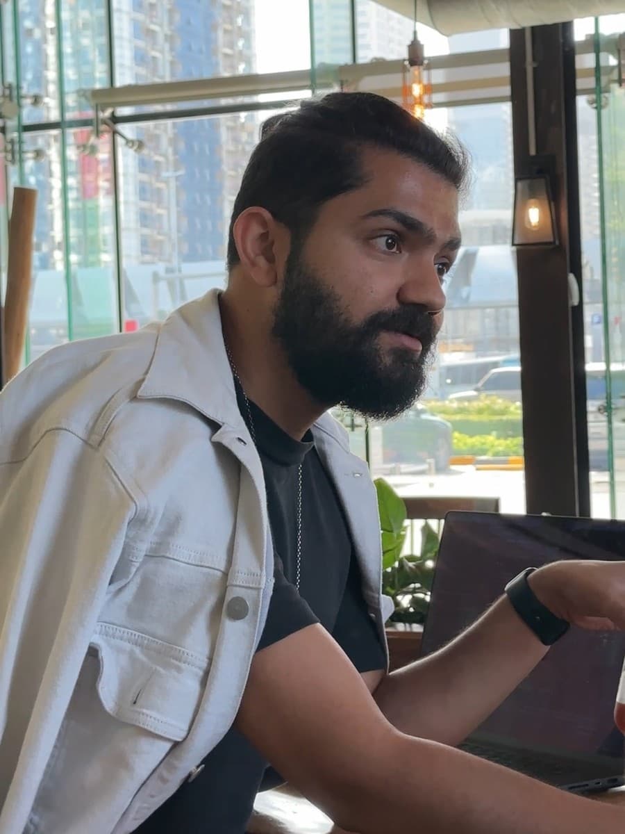 Asher Anjum working at a laptop in a Dubai cafe